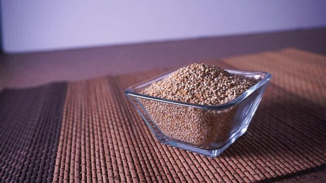 Quinoa org&aacute;nica en recipiente de cristal sobre mantel de bamboo