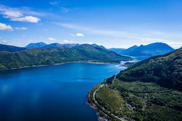 Naklejka na ściany i meble aerial image of the entrance to glencoe, ballachulish and loch leven from loch linnhe on the west coast of the argyll and lochaber region of the highlands of scotland on a clear blue sky summer day