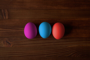 Colorful eggs for Easter on a wooden table. View from above.