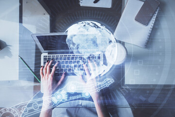 Double exposure of woman hands working on computer and world map hologram drawing. Top View. International business concept.