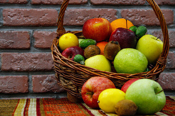Apples, kiwies and lemons in a wooden basket