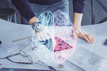 Double exposure of man's hand holding and using a digital device and brain hologram drawing. Data concept.