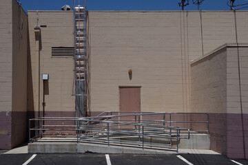 The rear side of a common storage building with a back door, a ramp and a ladder to the roof
