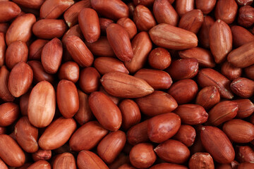 Pile of raw peeled peanuts situated arbitrarily. View from above.