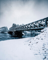 Iron bridge over the water in the snow