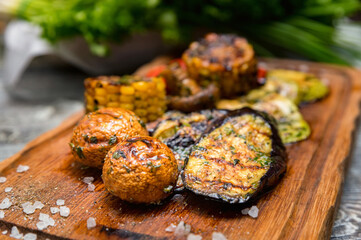 Various tasty grilled vegetables and mushrooms on rustic background