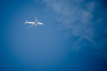 Airplane flying across a blue sky.