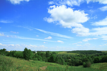Fototapeta premium Beautiful summer landscape of nature countryside. Green vegetation of grass and trees with hills. Stock photo for design