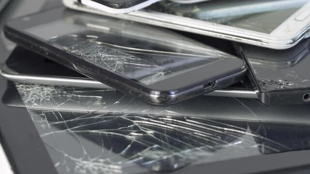 Broken touch screen on  used crashed gudget  and Mobile Smart Phone and pad heap,  Devices are prepared for utilization lying one on top of another.