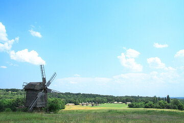 Naklejka premium Landscape on a summer day against the backdrop of a beautiful ancient village with beautiful houses and mills. Stock photo for design