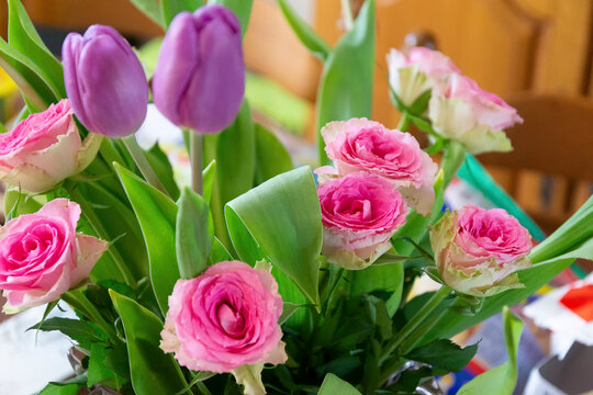 photo d'un bouquet de fleurs composé de tulipe mauve et de rose fuchsia avec leur feuillage vert