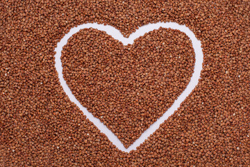 Drawn heart on buckwheat scattered on the table