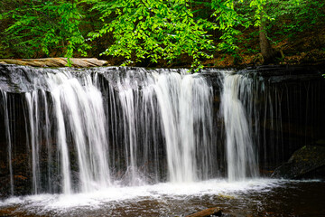 Fototapeta na wymiar Large waterfall at Rickett's Glen State Park in Pennsylvania with a beautiful basin.