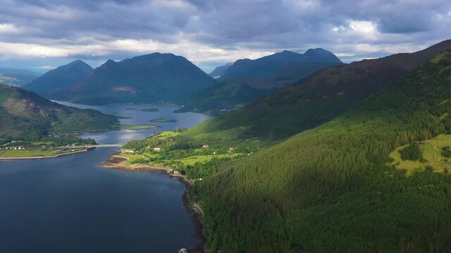 aerial footage of the entrance to glencoe and ballachulish towards loch leven on the west coast of the argyll and lochaber region of the highlands of scotland on a clear blue sky summer day