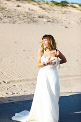 Fototapeta na wymiar An attractive trendy blonde young bride in a beach