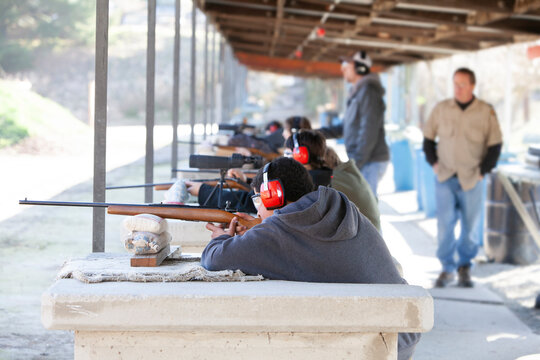 Young men shooting rifles at gun range