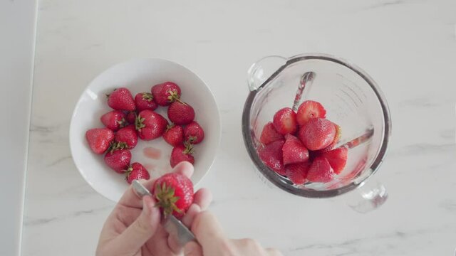 Cutting Strawberries Making Milkshake Smoothie, Preparing Fruits For Cocktail In Home Kitchen With Knife, Overhead Top View.