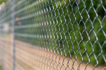 Selected focus or close up view of green metal grill fence and blur background of green natural...