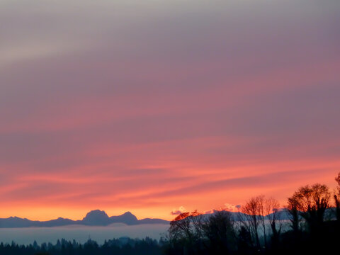 Sunrise over Cascade Mountain Range in Washington State with violet, orange, and yellow sky.