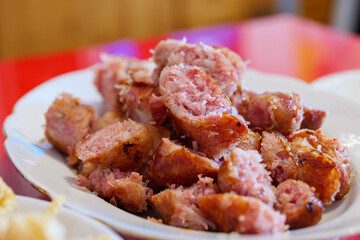 Close up view, Sliced Homemade North East Thai Sausage, Isan Sausage, on white plate.