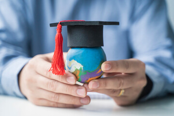 Learning and education teacher holding playdough world, graduation hat creative thinking improving...