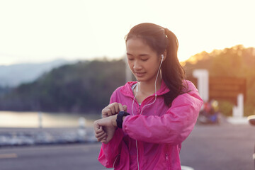 Close up athlete Asian young girl smiling happy listening music running exercise using smart watch...