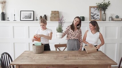 Three women are putting things away in the new apartment