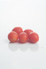 Cherry tomato( Solanum lycopersicum var. cerasiforme),isolated over white reflective background