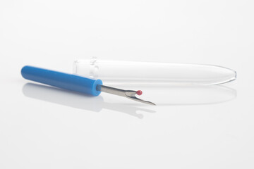 seam ripper isolated over white reflective background