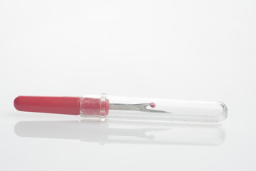 seam ripper isolated over white reflective background