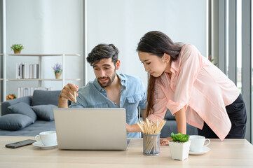 Happy and relax  lifestyle of young couple lover wearing casual dress together working on laptop notebook computer in living room at home.