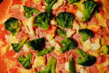 Sliced pizza with broccoli and cheese, close up view