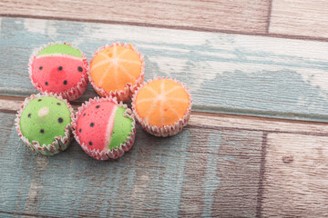 Unsorted cup cakes spread over wooden background