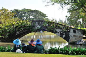 Fototapeta na wymiar Unidentified Park Gardeners Resting Near a Bridge