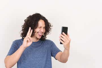 Portrait of Asian man smiling and holding mobile phone for selfie, video call or playing social media