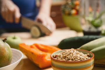 woman's hands cutting cucumber on a wooden board