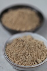 Guarana powder in ceramic black and gray cups on a light marble background.Useful  Healthy eating.Natural energetic.Super food