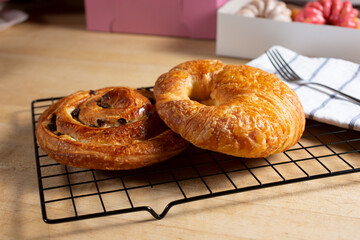 A view of a raisin roll and croissant in a donut shop still life setting.