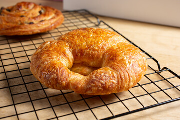 A closeup view of a croissant, in a still life setting.