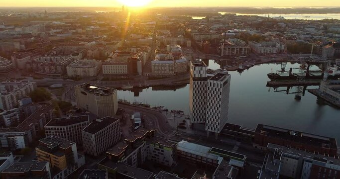 Aerial, tracking, drone shot overlooking buildings in Jatkasaari district and the Punavuori cityscape. on a sunny morning sunrise, in Helsinki, Finland