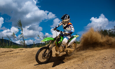 Naklejka premium Motocross rider lifting a dirt cloud on the air with rear tire.