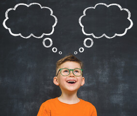 Child thinking with a thought bubble on the blackboard concept for confusion, inspiration and solution.