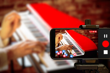 music vlogger streaming a live video while playing piano at home - obrazy, fototapety, plakaty
