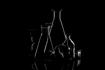 Low-key Studio Shot of a White silhouette of a chemical laboratory utensils light glasses isolated on a black Background. Smooth lines and shapes. .