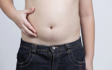 Naklejka premium hand holding excessive belly fat on gray background. concept of surgery and subcutaneous fat breakdown.