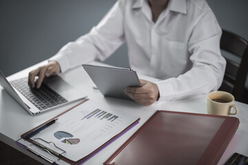 businessman working on desk and using laptop calculator and pad look very busy, work from home concept.