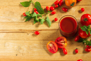 Top view, Tomato juice in clear glass On the wooden table Decorate with small and large fruits.
