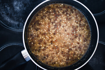 plant-based food, vegan potato and leek buckwheat with lentils in pot on stove