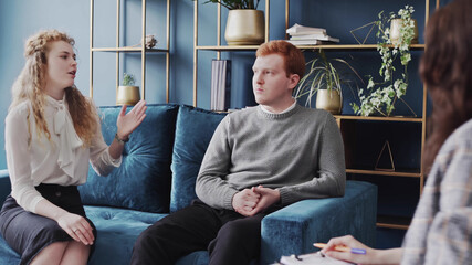 Young couple quarreling in front of a family psychologist