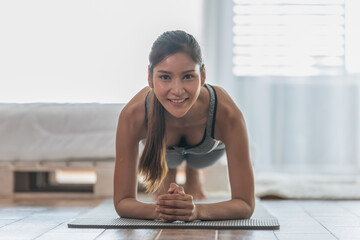 Obraz premium Attractive Asian woman practice yoga Plank pose at home